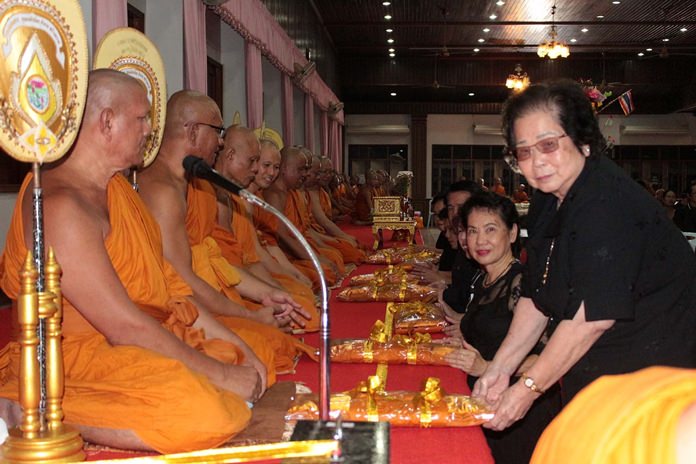 Devout Buddhists present robes to monks at Wat Chaimongkol for Tak Bat Devo.