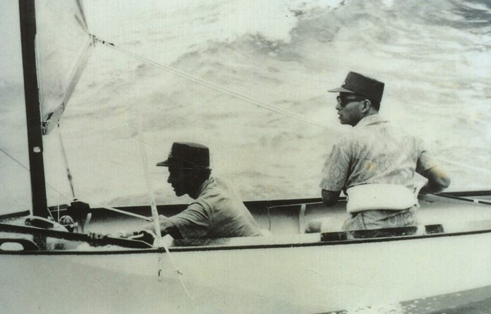 HM the King learning to sail, with his “tutor” HSH Prince Bhisadej.