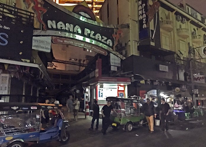 In this Oct. 14, 2016 photo, people walk past Bangkok’s Nana Plaza red-light district, after it closed down temporarily following the death Thursday of Thailand’s 88-year-old King Bhumibol Adulyadej, who was the world’s longest reigning monarch. (AP Photo/Todd Pitman)