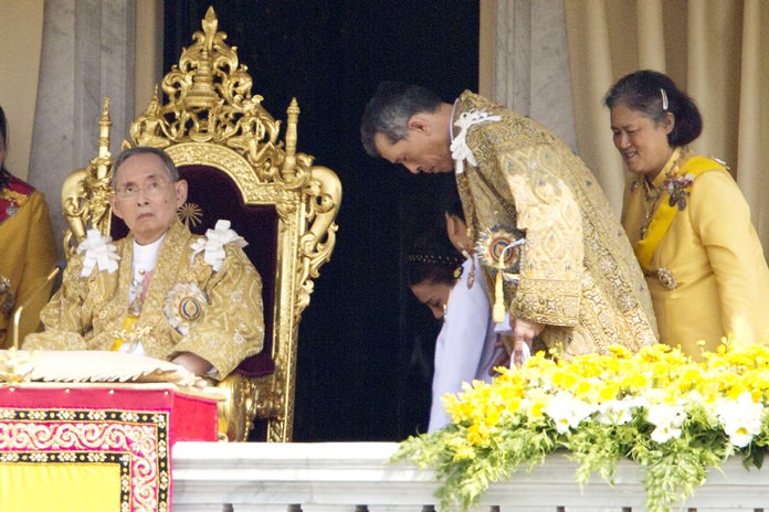 In this Dec. 5, 2012, file photo, His Majesty King Bhumibol Adulyadej, left, is seated as Crown Prince Vajiralongkorn, second left, and Princess Sirindhorn, right, stand after he addressed the crowd from a balcony of the Ananta Samakhom Throne Hall on his 85th birthday in Bangkok. (AP Photo/Wason Wanichakorn, File)