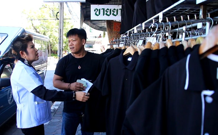 Department of Consumer Protection Director Bupha Songsakulchai checks prices of black attire at the Naklua Market and other clothing shops and street booths.