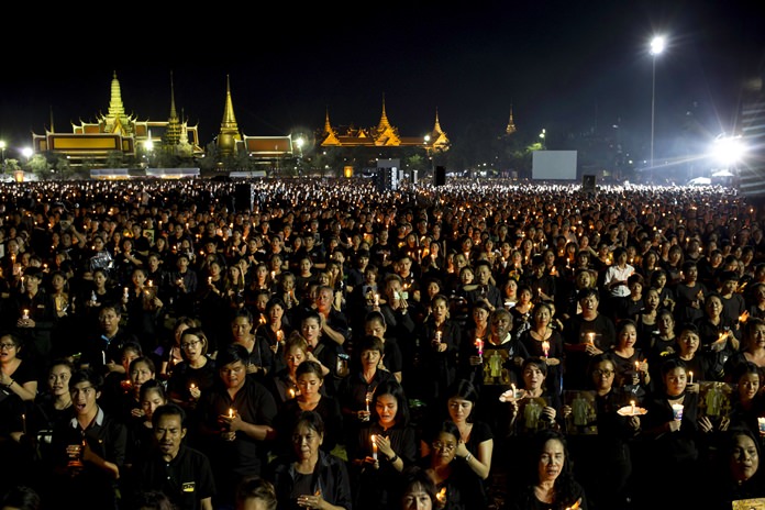 Mourners hold candles and sing Thailand’s Royal Anthem on the evening of Saturday, Oct. 22, 2016. (AP Photo/Wason Wanichakorn)