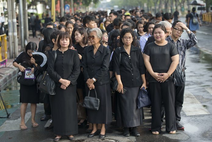 Thai people stand in lines to offer condolences for HM King Bhumibol Adulyadej the Great at Grand Palace in Bangkok, Friday, Oct. 14. Grieving Thais went to work dressed mostly in black Friday morning, just hours after the palace announced the death of their beloved King, the the world's longest-reigning monarch. (AP Photo/ Gemunu Amarasinghe)
