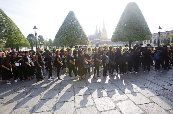 People line up to offer condolences for HM King Bhumibol Adulyadej the Great at Grand Palace in Bangkok, Thailand, Friday, Oct. 14, 2016. Grieving Thais went to work dressed mostly in black Friday morning, just hours after the palace announced the death of their beloved King Bhumibol Adulyadej, the world's longest-reigning monarch. He was 88. (AP Photo/Sakchai Lalit)