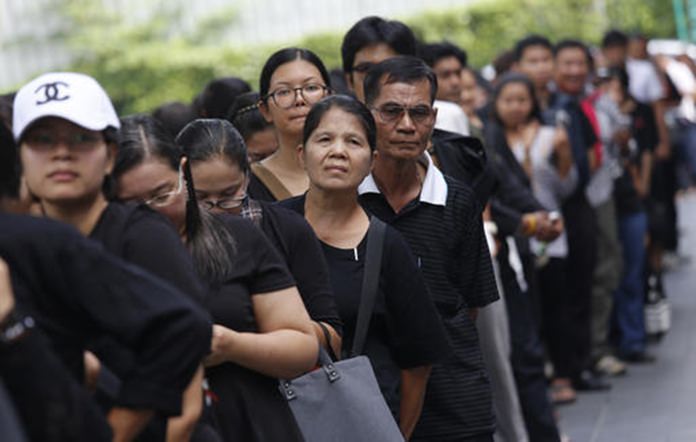 Mourners line up to buy commemorative banknotes in Bangkok.(AP Photo/Sakchai Lalit)