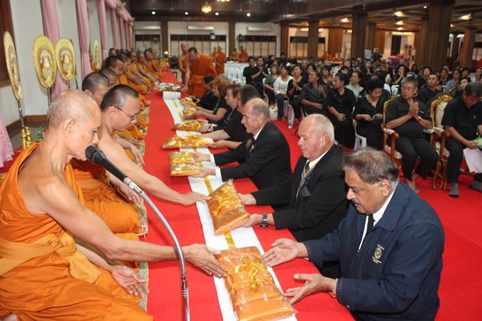 Rotarians make merit by presenting robes to the presiding monks.