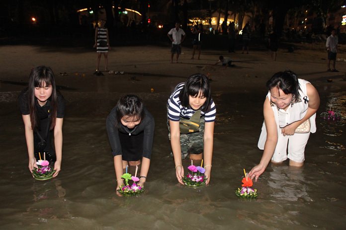 Families float their krathongs together along Pattaya Beach.