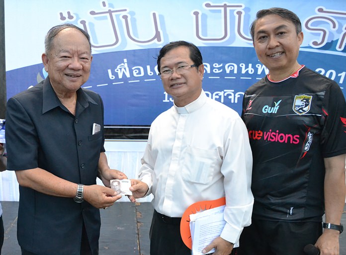 Nongprue Mayor Mai Chaiyanit presents a donation to Father Michael and Father Peter.