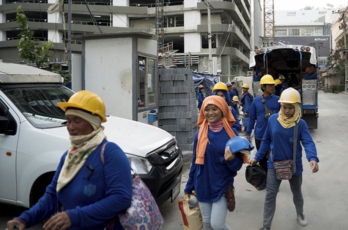 Cambodian migrant construction workers leave a building site in downtown Bangkok. (AP Photo/Dake Kang)