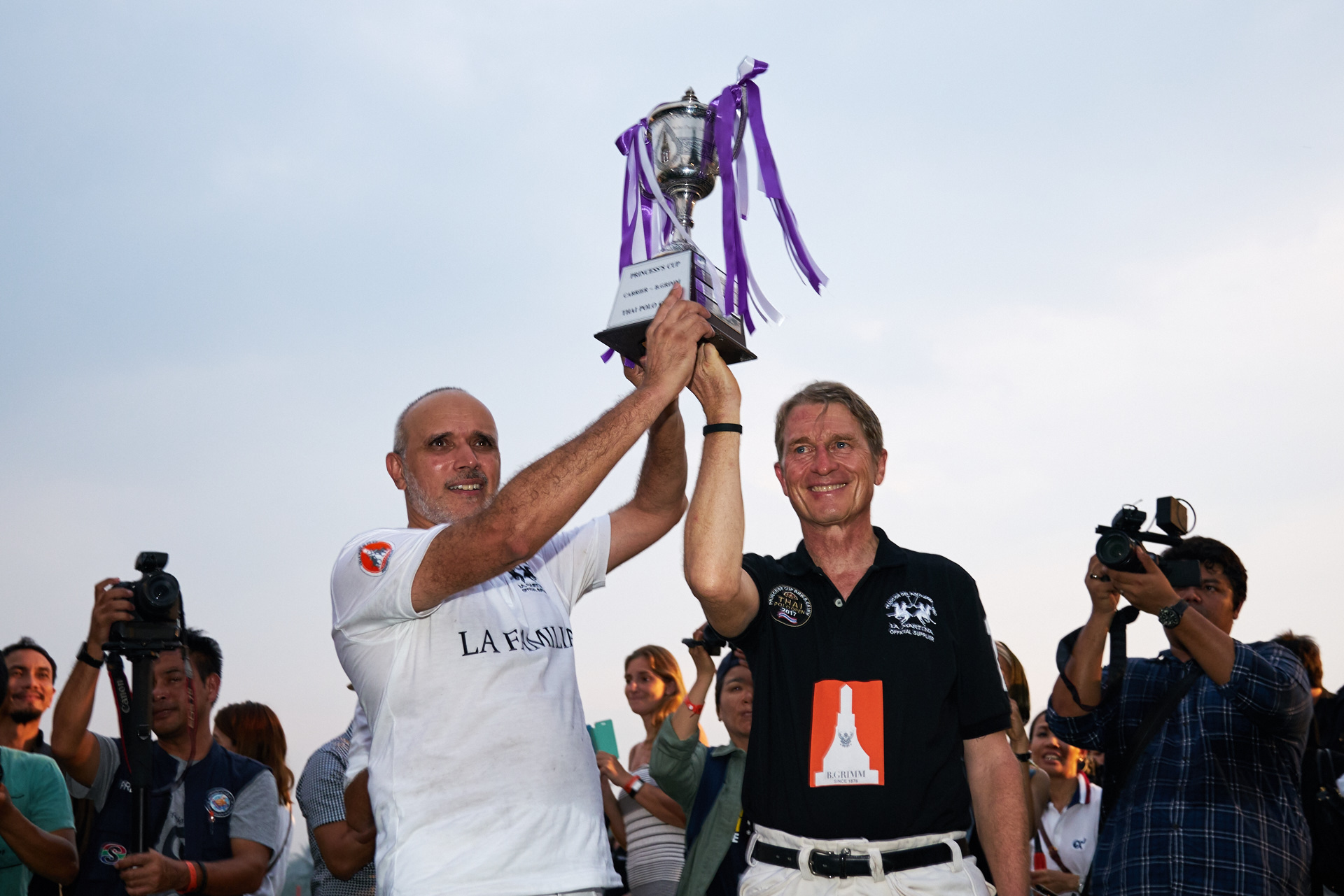 Team captains Mohamed Moiz of La Familia (left) and Harald Link of Thai Polo (right) jointly hoist the HRH Princess Sirindhorn Cup after the final of the 2017 Thai Polo Open was curtailed due to heavy rain.