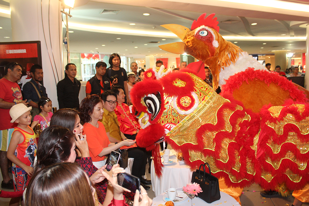 Officials feed Angpao to the dragon and rooster for luck at the Royal Garden Plaza.