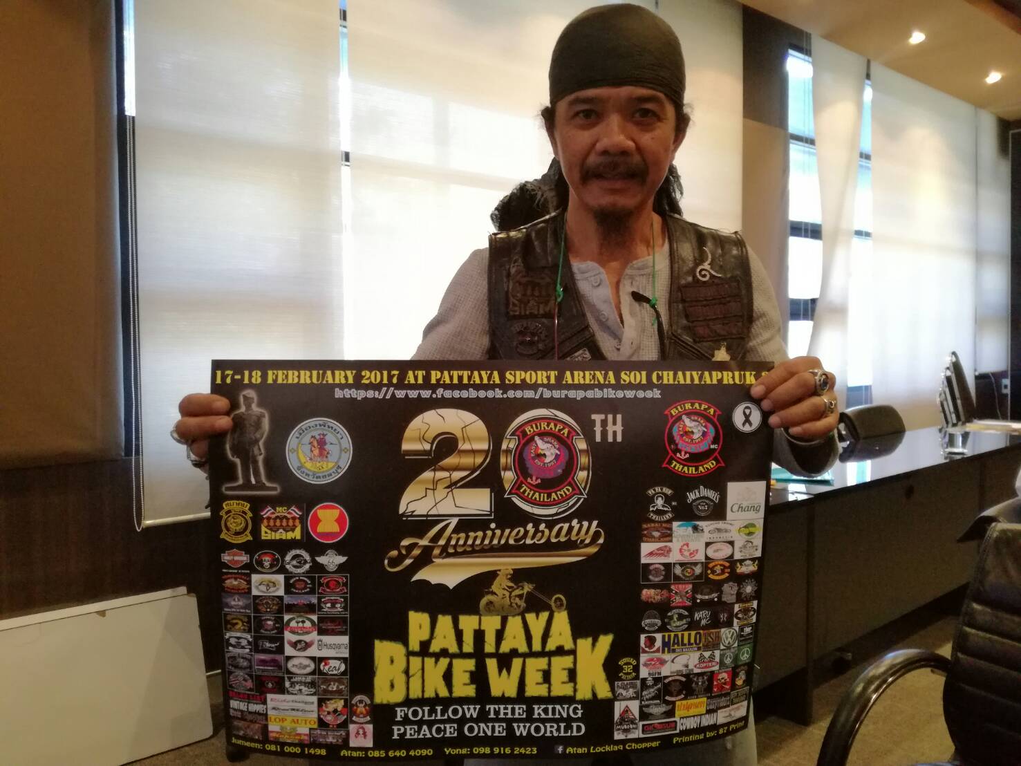 Prasan Nikaji, president of the Burapa Bike Club, holds up a poster announcing this year’s bike week.