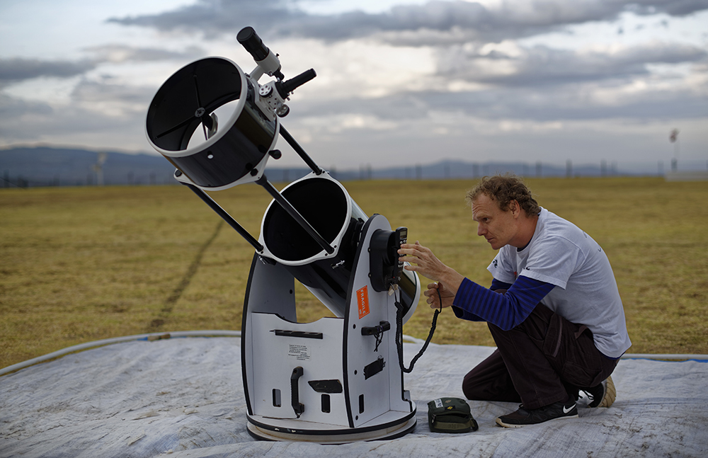 Astronomer and company co-founder Daniel Chu Owen sets up a telescope during a visit by The Traveling Telescope. (AP Photo/Ben Curtis)
