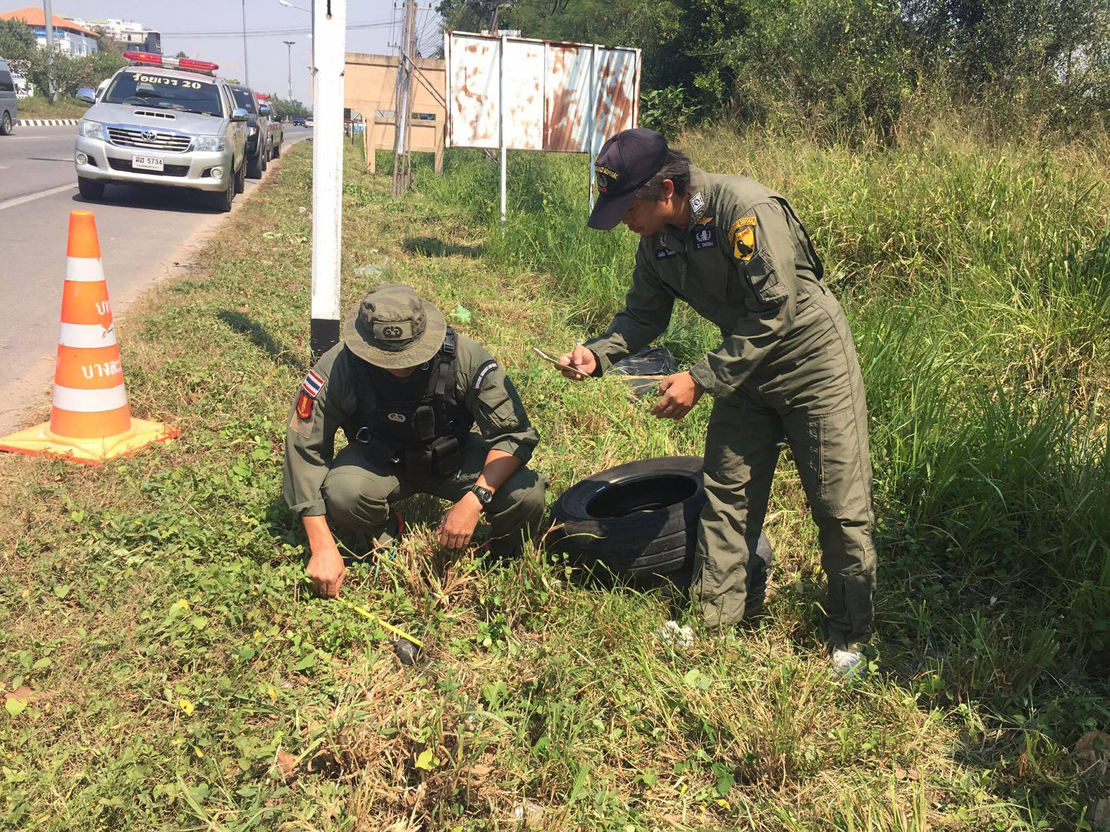 Bomb squad police begin the process of defusing an IED found on a Sattahip roadside.