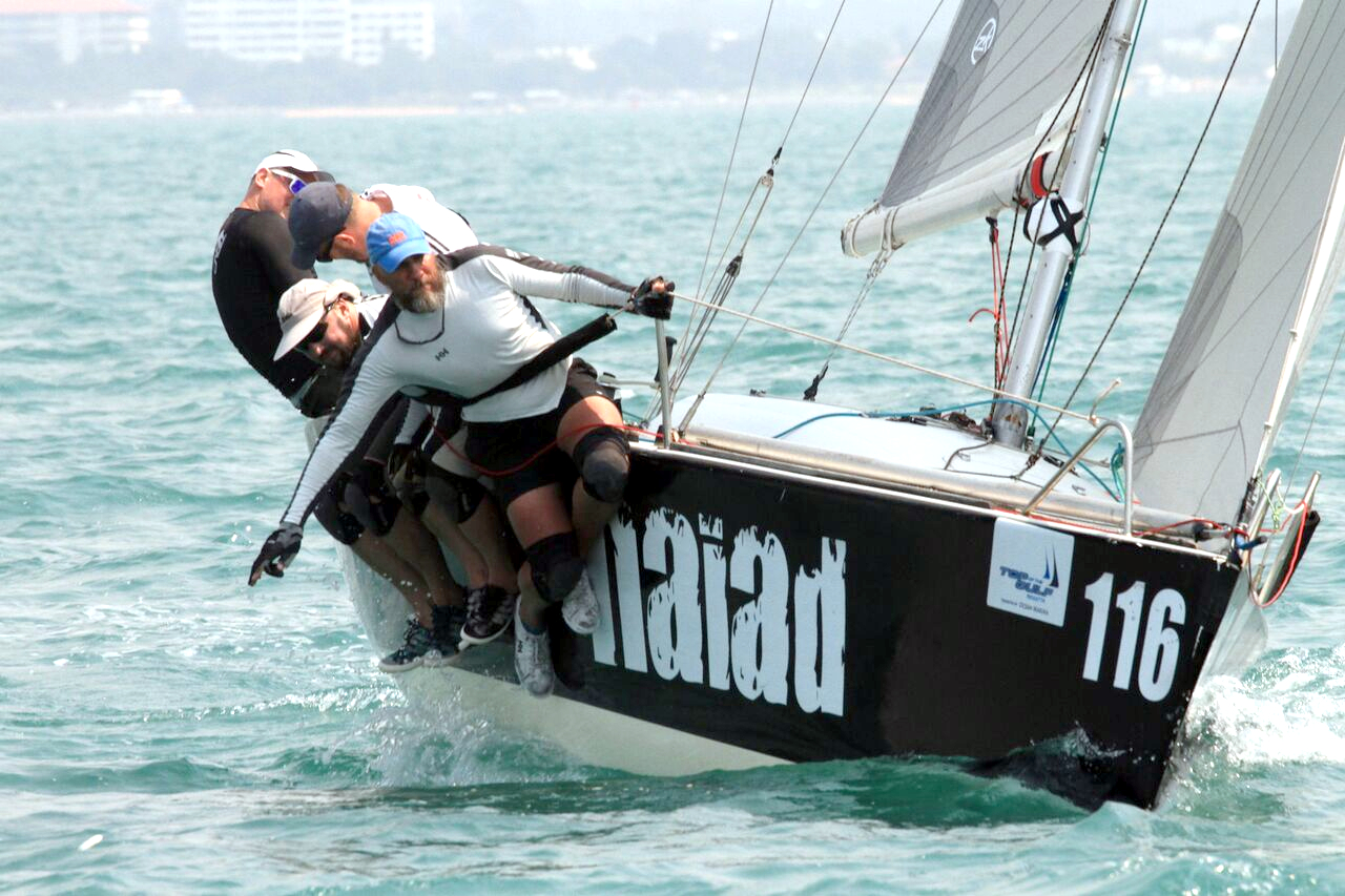 The crew on Naid balance the boat as it heels to port.
