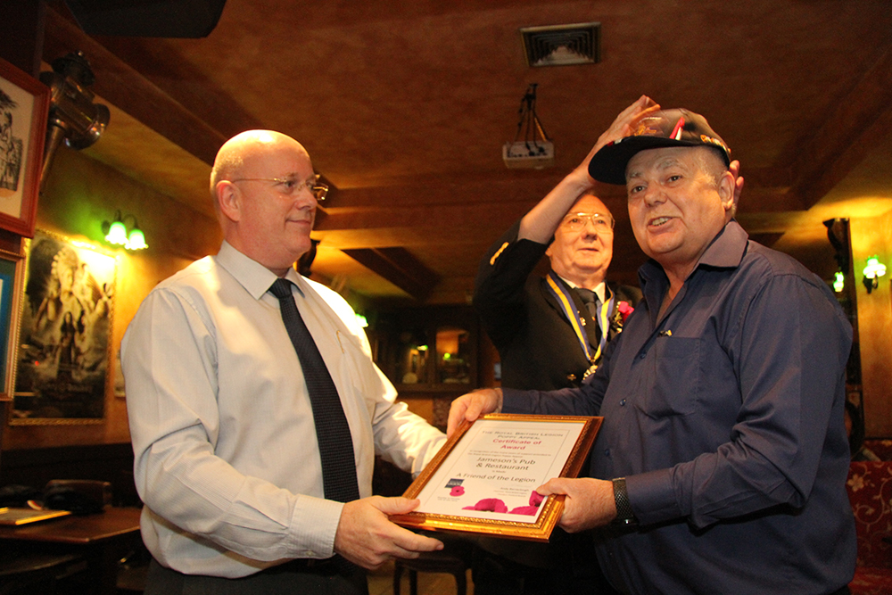 Graham Macdonald (left), President of the Royal British Legion Thailand presents Kim Fletcher (right) with a ‘Friend of the Legion’ Award, in recognition of the many years of outstanding support to the Royal British Legion Poppy Appeal in Thailand.