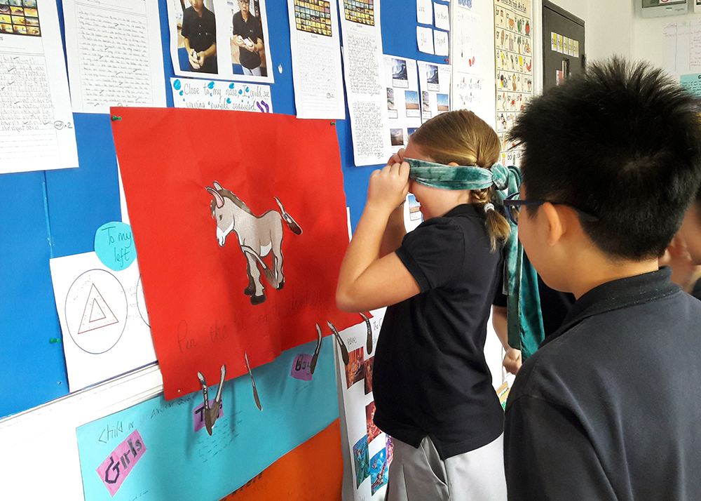 Primary pupils enjoy a game of Pin the Tail on the Donkey.