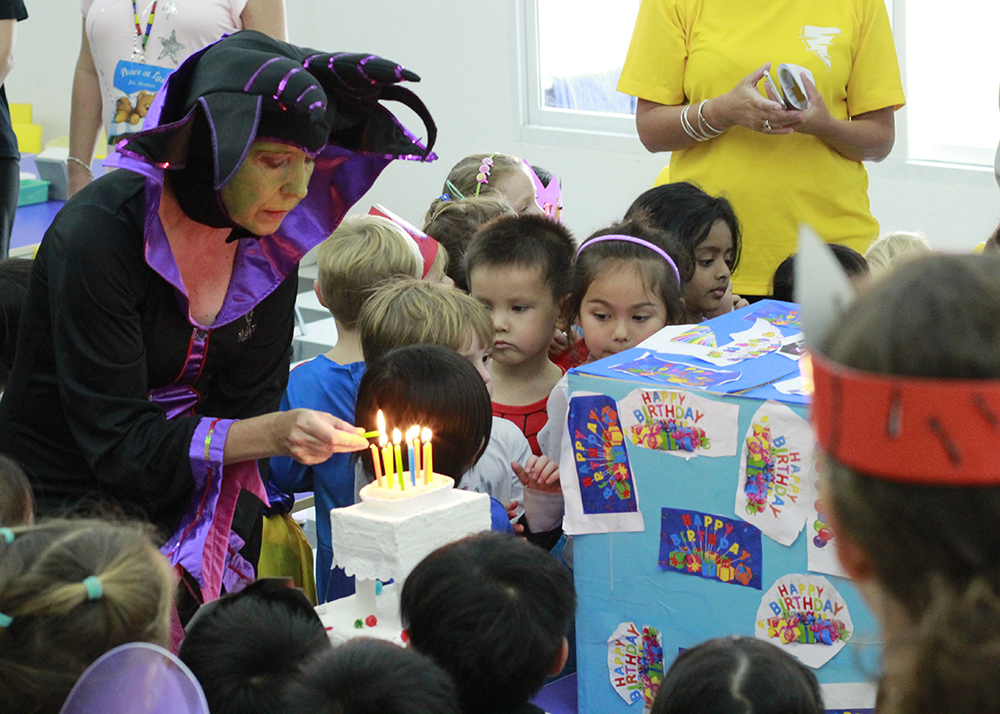 Nursery teacher, Jackie Crampton lights the candles as Maleficent.
