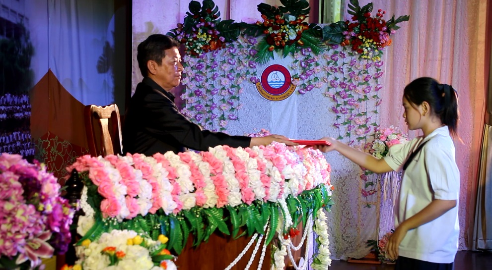 Principal Witsanu Pasomsab hands out a diploma to one of the graduating students at Banglamung School.