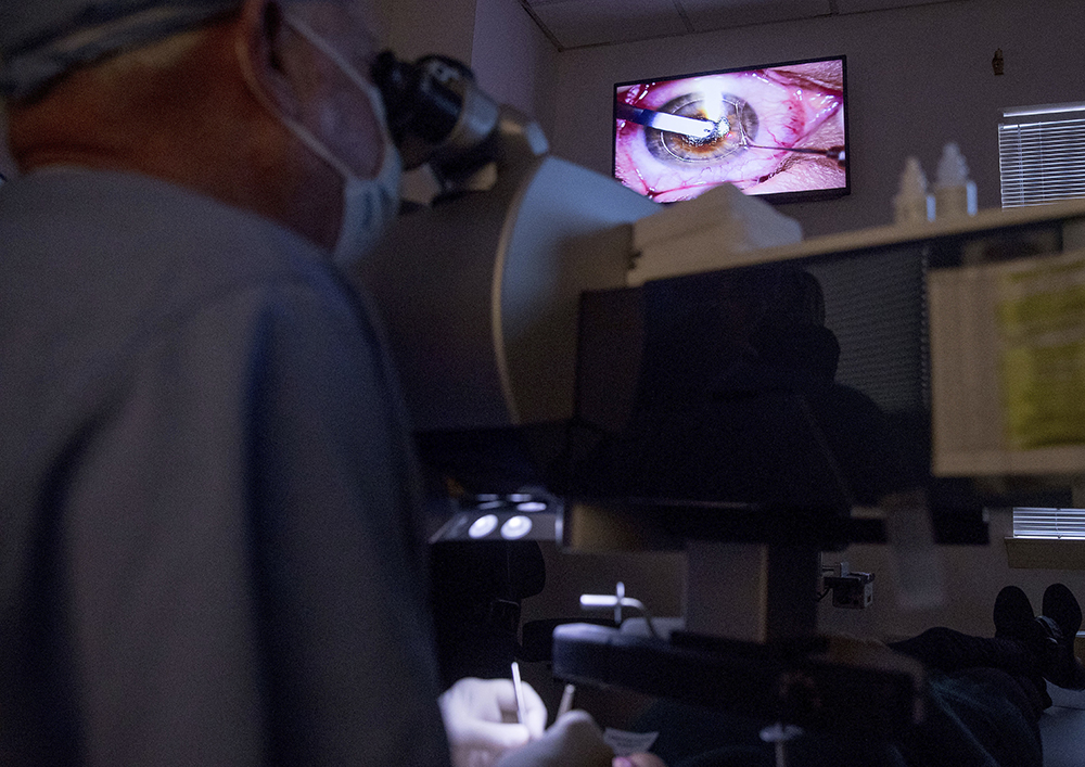 In this photo taken Feb. 1, 2017, a live video feed is displayed on a screen above Dr. Mark Whitten, left, as he performs a short eye surgery procedure on patient Christianne Krupinsky in Washington, to insert a Raindrop inlay, a disc implanted in the cornea to reshape it for better close-up focus. This new kind of eye implant corrects presbyopia, the need for reading glasses that eventually hits all of us, usually starting in the 40s. (AP Photo/Andrew Harnik)