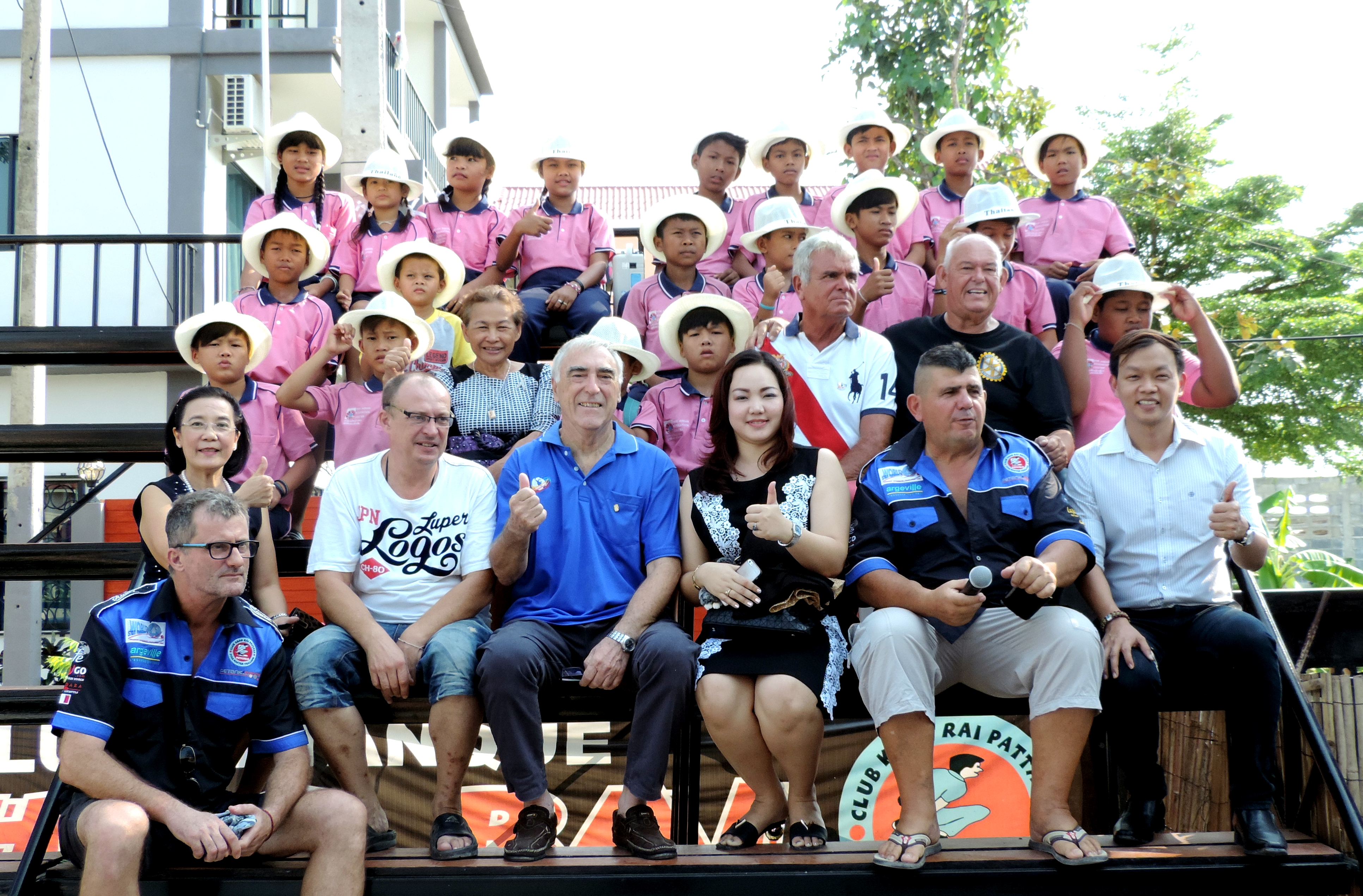 Children under the care of the Human Help Network Foundation Thailand pose with Rotary Club members at the conclusion of the petanque day.