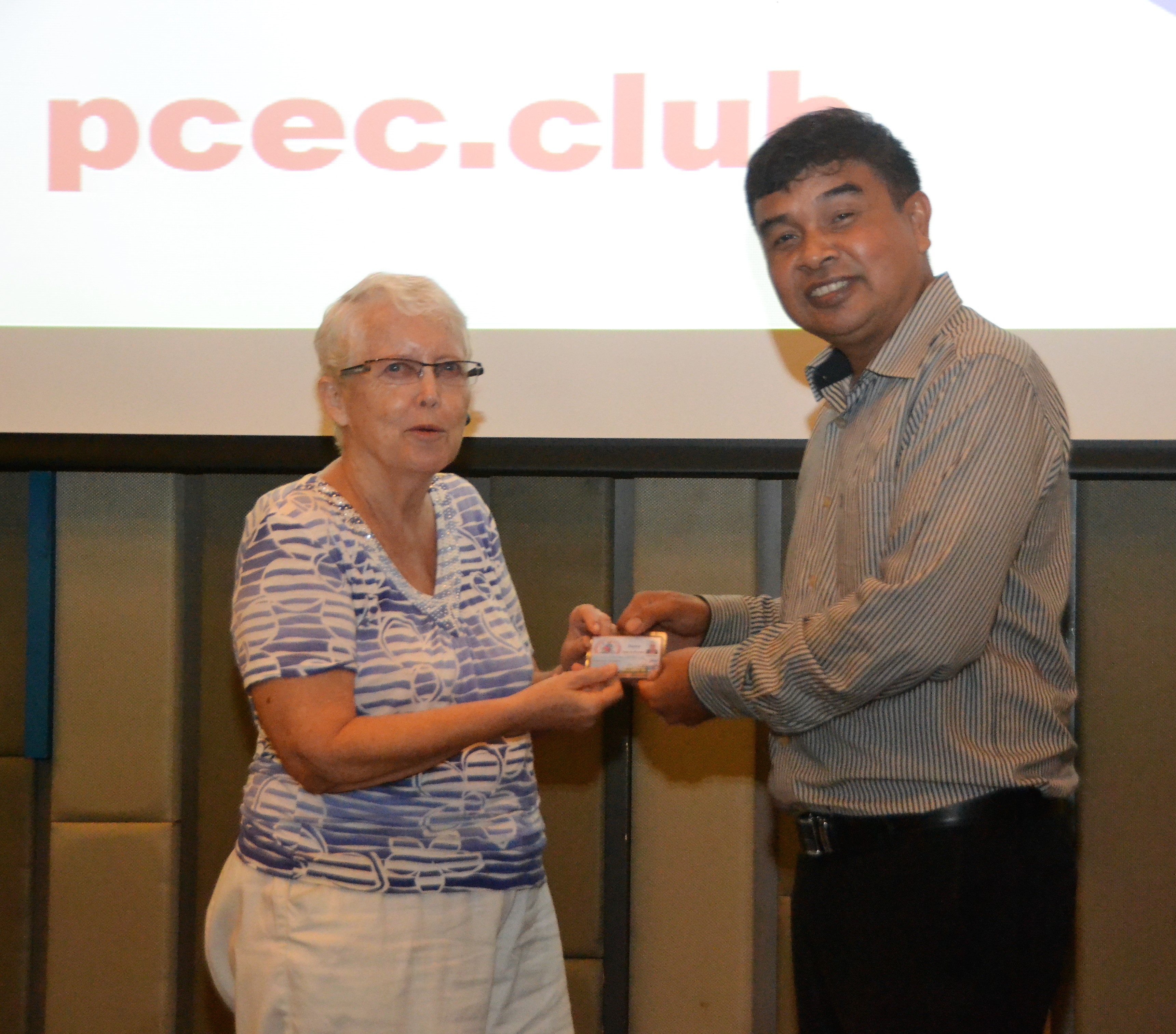 Chatchai Sriphoornthe, Deputy Chief for Banglamung District, presents Club member Donna Westendorf with her Commemoration Card from the District.