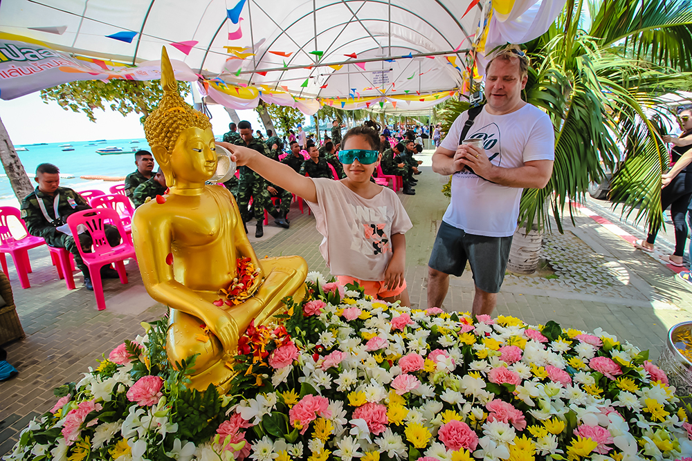 Respecting tradition and pouring scented water on the Buddha statue.