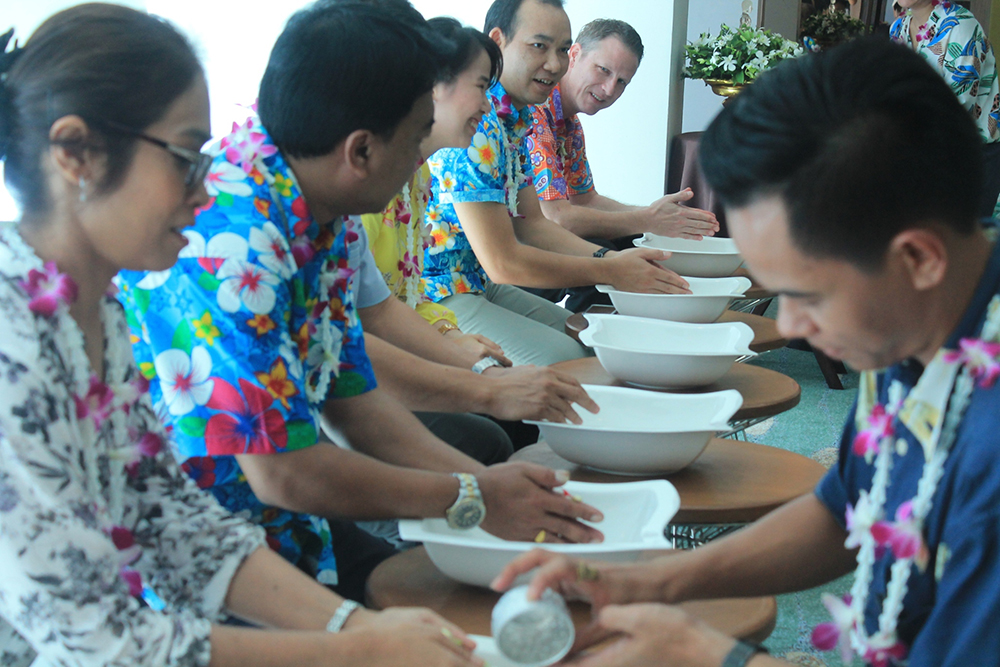 Management staff receive water poured through their palms by the younger as a way to show respect in the Thai culture.