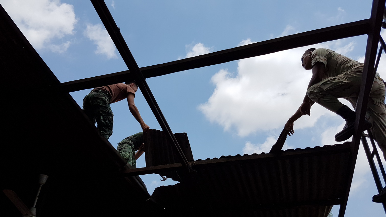 Workers repair a home that was affected by the recent storms 