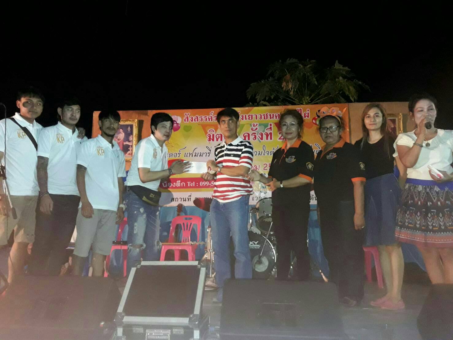 Jirawat Plukjai (right/center), Chairman of the Chumsai Community, hands over money raised for the anti-drugs message to keep youths on the right path in the Soi Khopai Community.