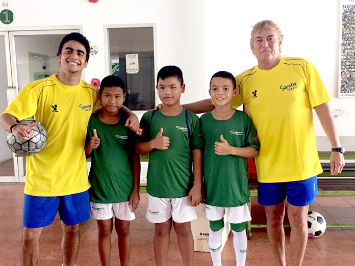 Lionel Izaaks (right) and Gabriel Albequerque (left) from the Samba Soccer academy in Pattaya pose with budding football stars at the Father Ray Children’s Home, Wednesday, May 10.