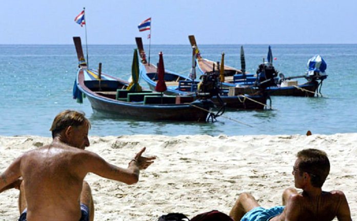 Western tourists soak up the sun on Kata Beach, Phuket. (AP Photo)