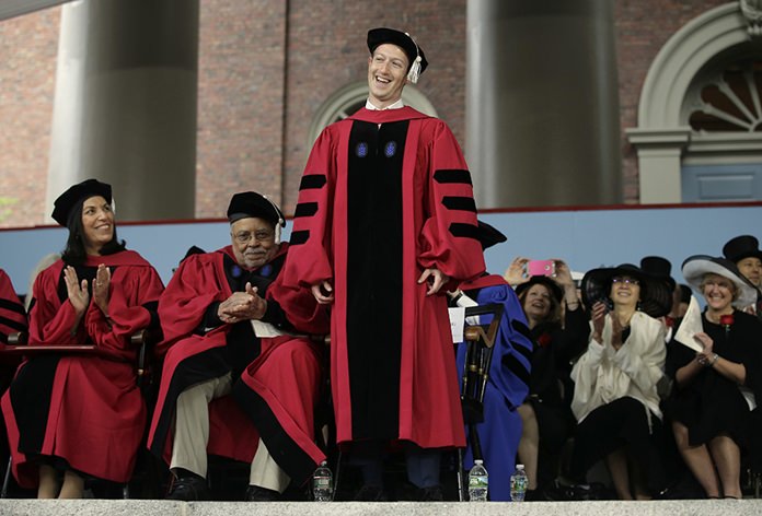 Facebook CEO and Harvard dropout Mark Zuckerberg, center, smiles as he is introduced before being presented with an honorary Doctor of Laws degree as Baylor College of Medicine professor Huda Zoghbi, left, and actor James Earl Jones, second from left, applaud during Harvard University commencement exercises, Thursday, May 25, 2017, in Cambridge, Mass. (AP Photo/Steven Senne)