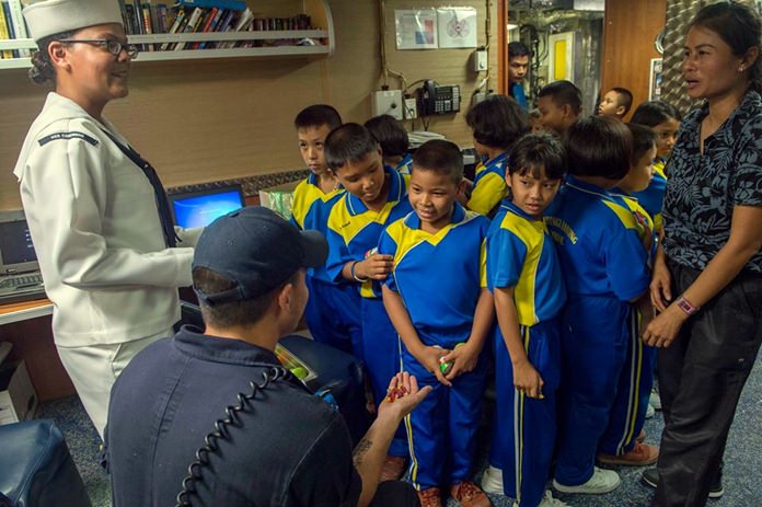 Sailors aboard littoral combat ship USS Coronado (LCS 4) interact with children onboard the ship as part of a tour during Cooperation Afloat Readiness and Training (CARAT) Thailand.