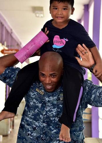 Capt. Alexis Walker, Deputy Commander, Destroyer Squadron 7, raises a school child onto his shoulders from Banntunggard School during a community outreach event as part of Cooperation Afloat Readiness and Training Thailand 2017 May 31. (U.S. Navy photo by Mass Communication Specialist 1st Class Micah Blechner