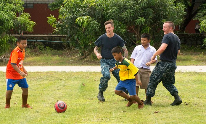 Sailors assigned to littoral combat ship USS Coronado (LCS 4) play soccer with children at Ban Banglamung School.