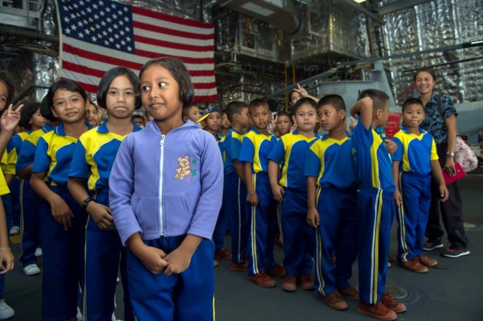 Children from local schools prepare for a tour aboard littoral combat ship USS Coronado (LCS 4).