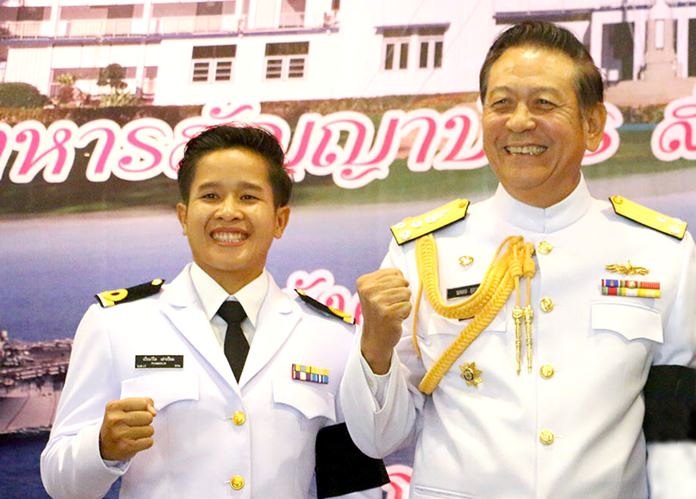 Thai boxer Piamwilai Laopium (left) gestures with Vice. Adm. Noppadol Supakorn after receiving her navy ranking at Sattahip Naval Base on May 30.