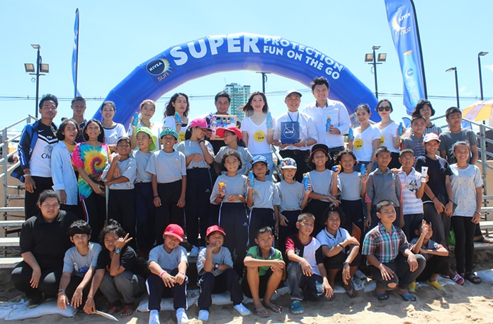 Chatasri Jaruchet, general manager for the Nivea Sun line, and Rev. Peter Pattarapong Srivorakul, president of the Father Ray Foundation treat children to a day at the beach.