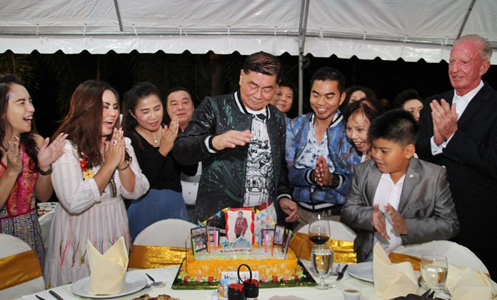 Retired Gen. Boongerd Wadwaree blows out the candles on his birthday cake surrounded by family and friends at the Thai Garden Resort. Hotel owner Gerrit Niehaus (right) applauds the fun.