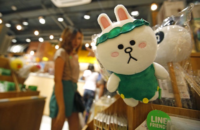 A customer selects merchandise at Line Village in Bangkok, Thailand, Thursday, June 22, 2017. (AP Photo/Sakchai Lalit)