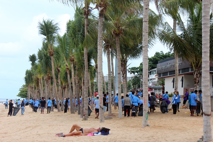 A lone sun worshipper lays out on the beach as scores of cleaners wander around behind him. About 500 people picked up scrap and flipped over sand as Pattaya continued its summertime beach cleanup July 5, banning beach chair vendors on Wednesdays and Thursdays for at least the rest of the month. The two-day beach closures have garnered scores of complaints from tourists.
