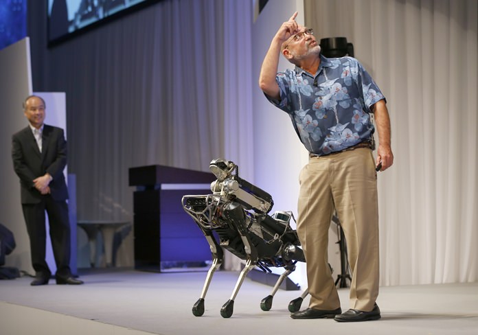 Boston Dynamics Chief Executive Marc Raibert, right, gestures beside his four-legged robot SpotMini as SoftBank Group Corp. Chief Executive Officer Masayoshi Son, left, watches him on stage during a SoftBank World presentation at a hotel in Tokyo, Thursday, July 20, 2017. (AP Photo/Shizuo Kambayashi)