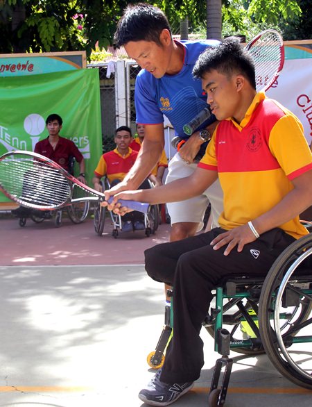 Danai Udomchok gives advice to one of the wheelchair tennis players.
