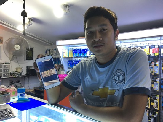 Jirdej Nomnoey, shows an image of the fake banknote on his phone.