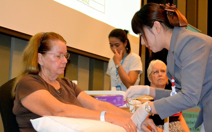 A nurse from PIH inserts a small laser tube into a vein of one of two PCEC volunteers for a one hour session to demonstrate the use of the Bio-Laser.
