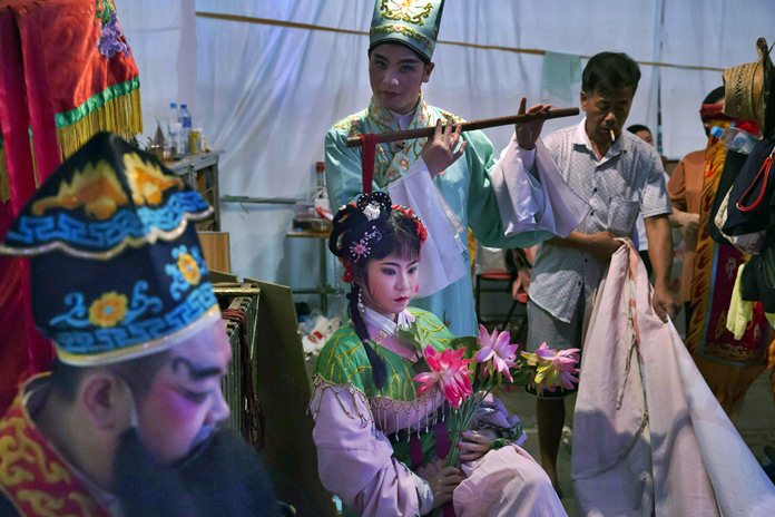 Chinese opera performers wait at a makeshift theater. (AP Photo/Kin Cheung)
