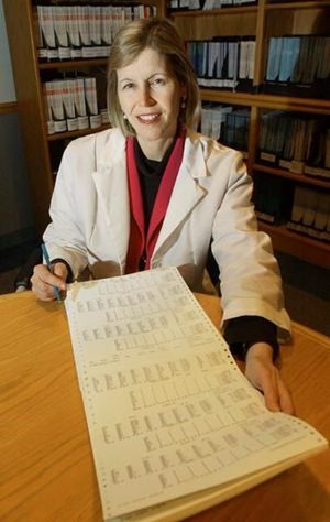 In this Dec. 12, 2002 file photo, Dr. JoAnn Manson poses with a printout from a study she directed on hormone replacement therapy for women at her office in Boston. In research results released on Tuesday, Sept. 12, 2017, Manson said hormones may be appropriate for some women when used short-term to relieve hot flashes and other bothersome menopause symptoms. (AP Photo/Elise Amendola)