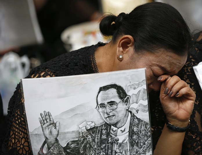 A mourner cries and holds a portrait of the late King Bhumibol Adulyadej at Siriraj Hospital where he died in Bangkok, Thailand, Friday, Oct. 13, 2017. (AP Photo/Sakchai Lalit)