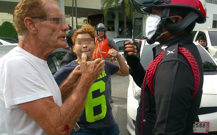 Local goldshop owner Sumate Rungrath, center, prepares to throw a punch at Australian national Gerrard Collins as he talks to a police officer at Aksorn Pattaya School on Soi Korphai, Wednesday, Oct. 11.